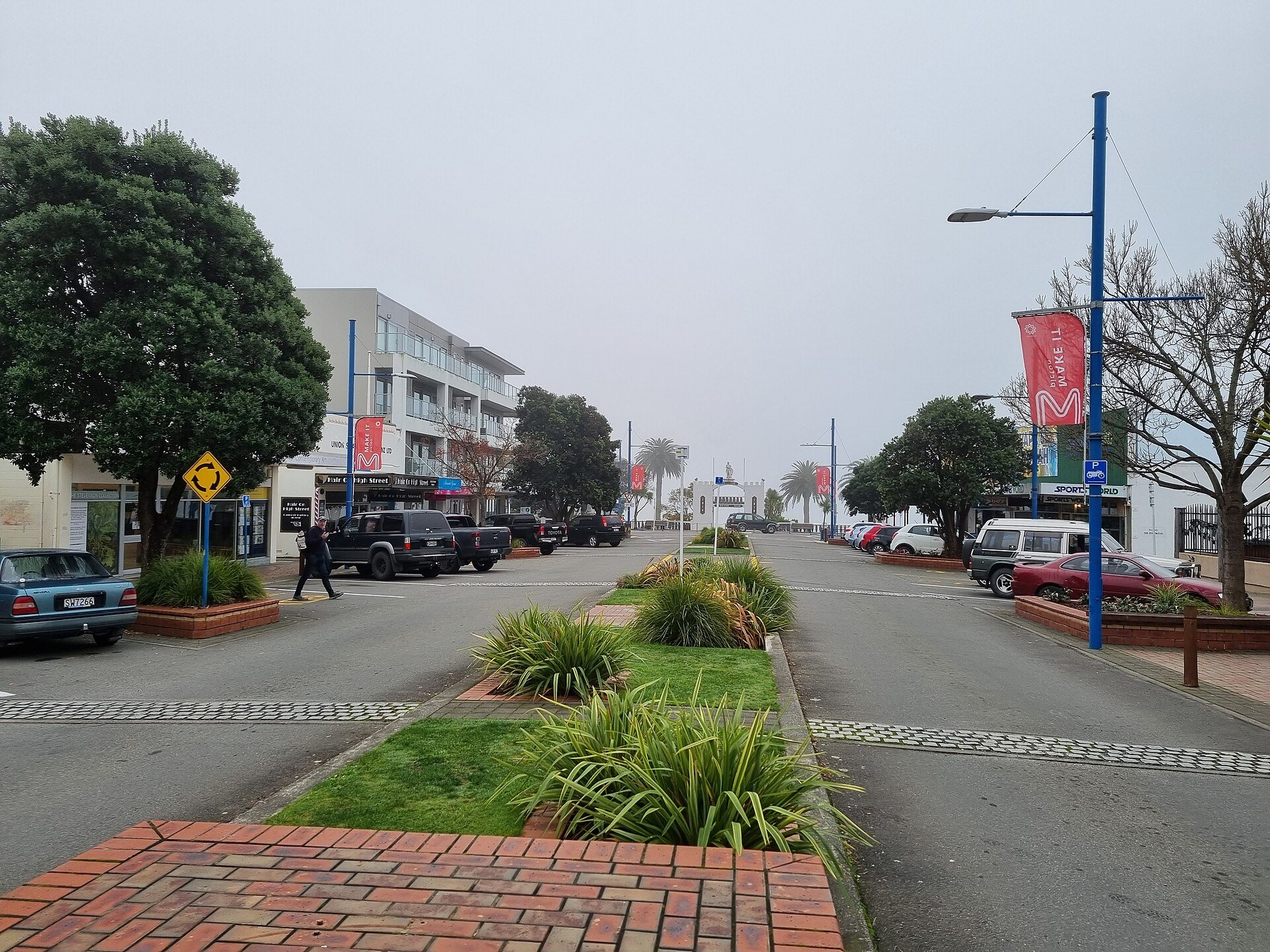 A Picton street with planted median, banners and low buildings, looking towards the hills