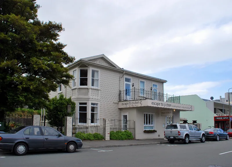 Cream weatherboard villa with an Escape to Picton sign on its verandah