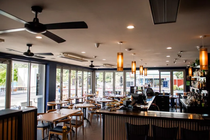 Wide view of Fork & Fable's dining room, bar, tables and street-facing windows.