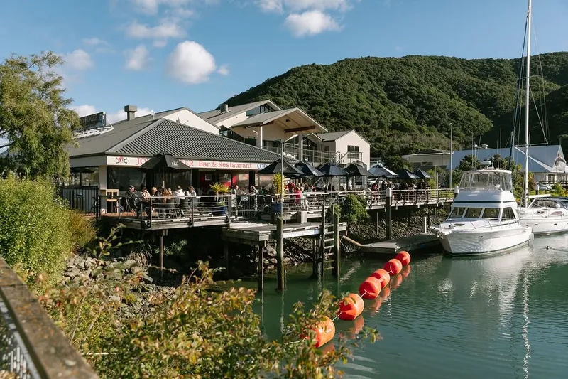 Jolly Roger waterfront building and occupied deck beside boats at Waikawa Marina.