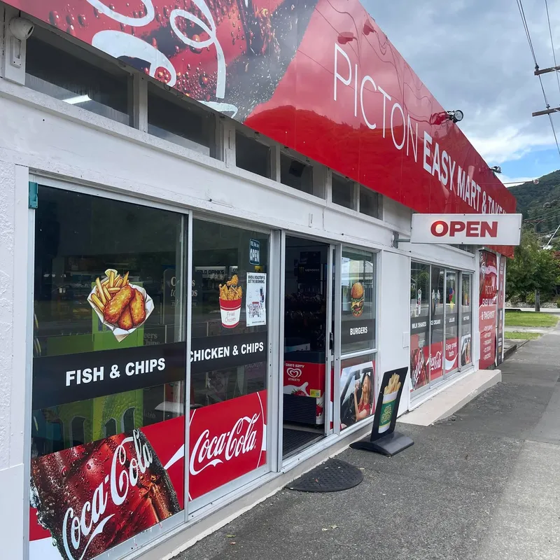 Angled view of the Picton Easy Mart & Takeaway shopfront, entrance, food decals and red fascia signage.