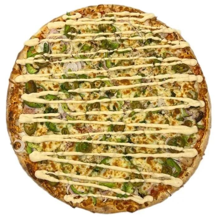 A whole baked pizza topped with green peppers and a pale sauce drizzle on a white background.