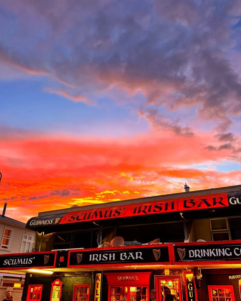 Seumus' red-and-black Wellington Street facade beneath a vivid sunset sky.